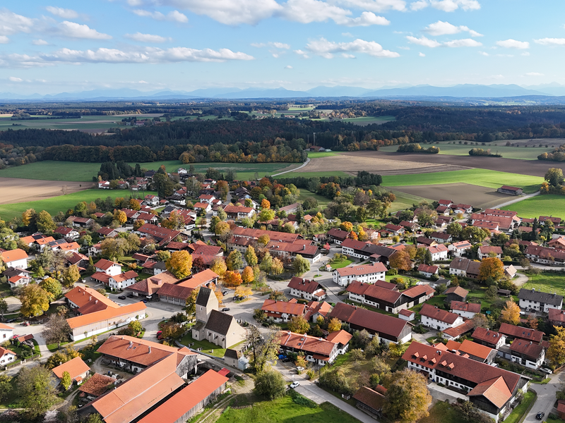 Ein Ortsteil in herbstlicher Stimmung mit einer Kirche im Kern. 