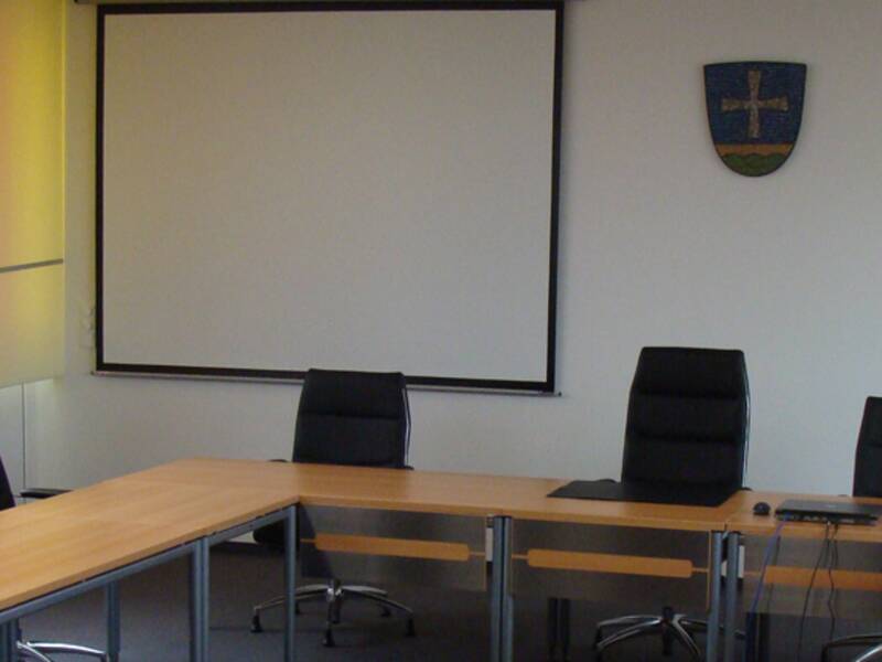 Sitzungssaal ein Tisch in U-Form mit Stühlen und Whiteboard
